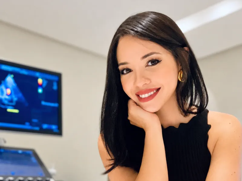 Retrato da Dra. Alinne Barbosa sorrindo na sala de exames