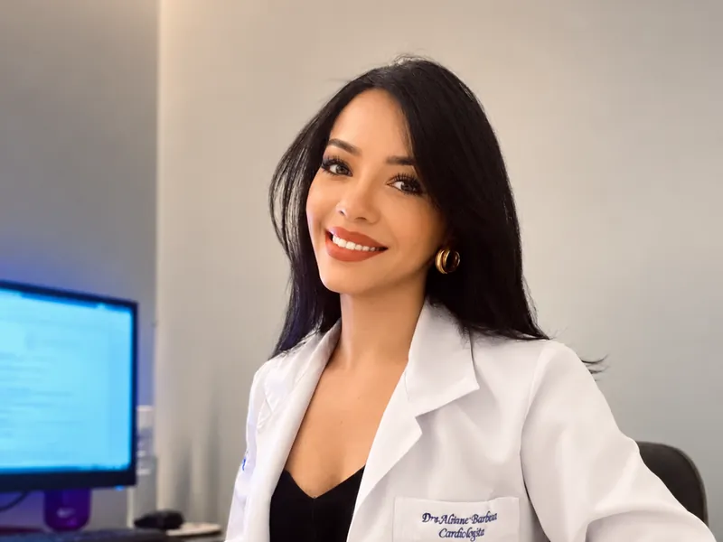 Dra. Alinne Barbosa de jaleco com o nome bordado, cardiologista